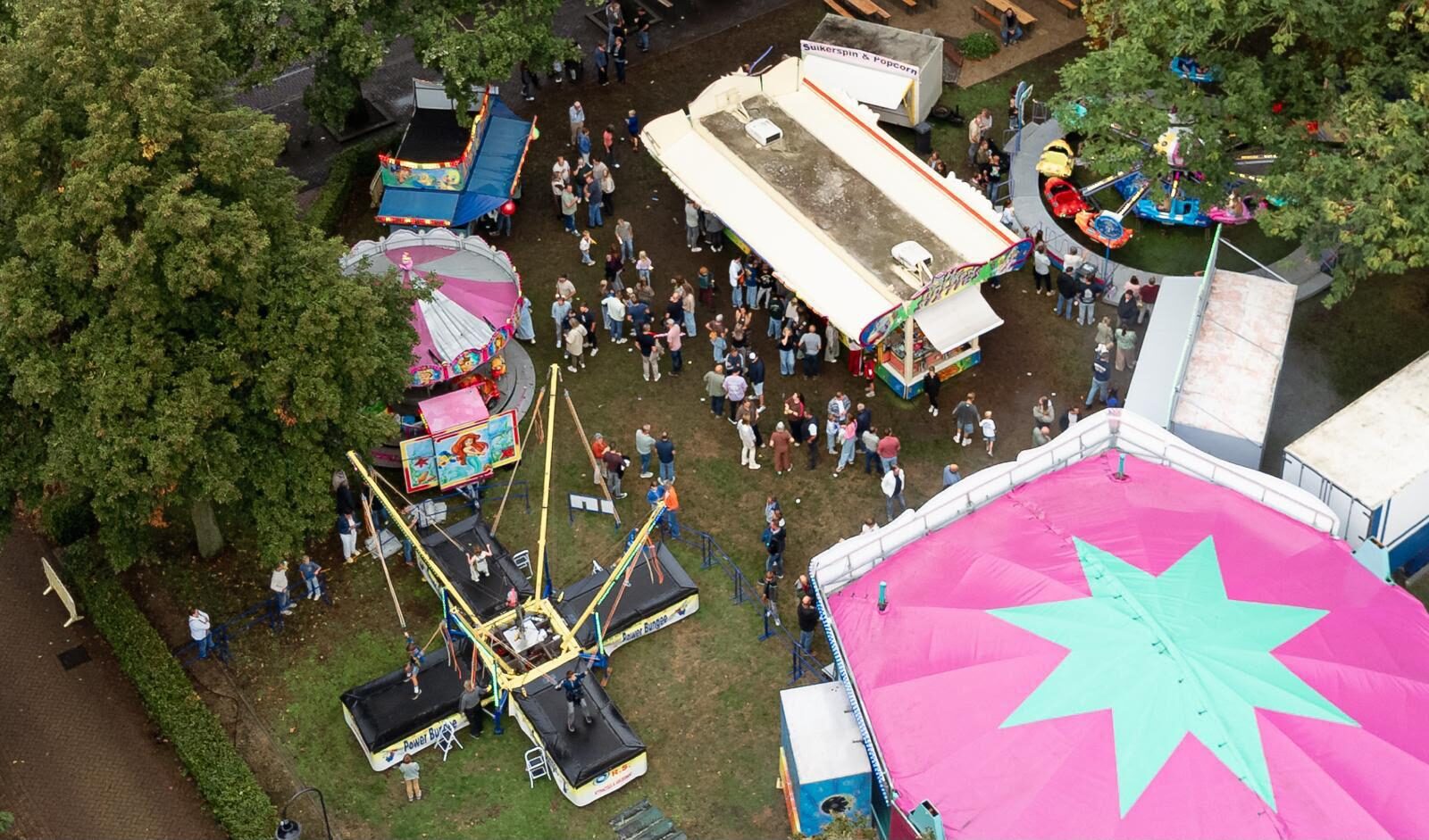 De kermis in Helenaveen vanuit de lucht, met de attracties, de kramen en de feesttent